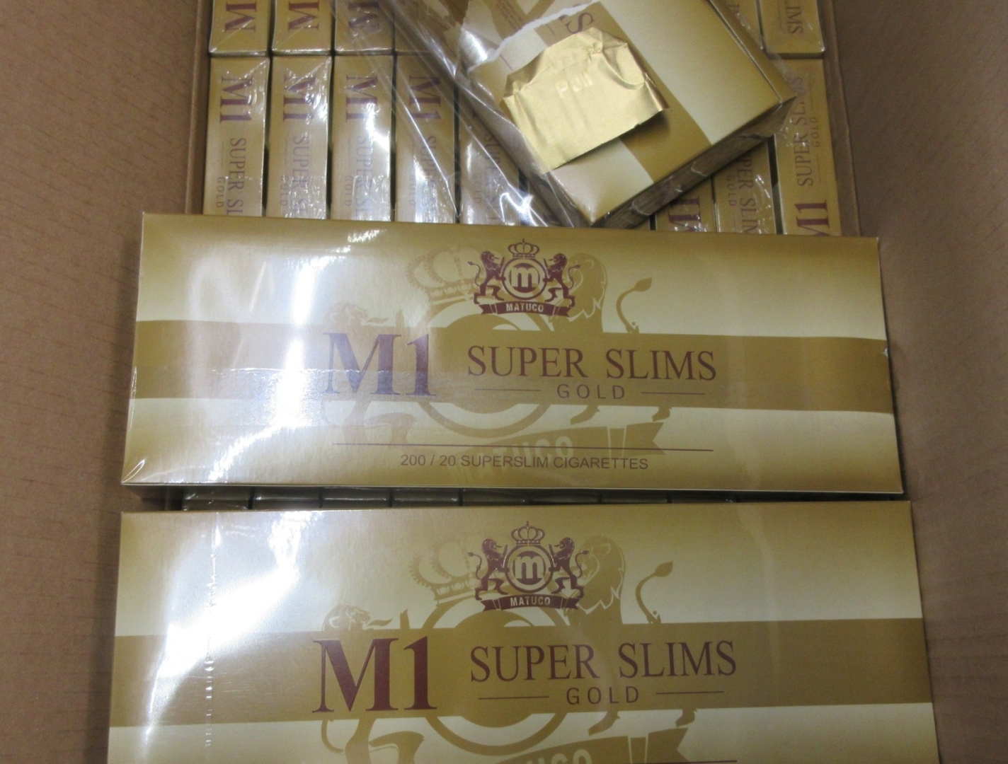 Kartona kastē iepakojumi ar kontrabandas cigaretēm M1 Super Slims Gold 