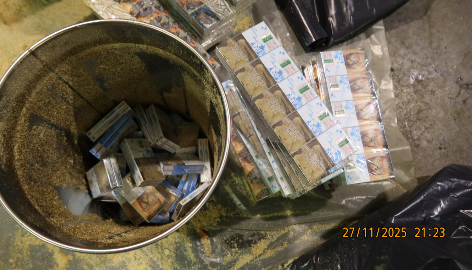 Kontrabandas cigaretes, kas paslēptas aizvākotos metāla spaiņos, zem zāģskaidām