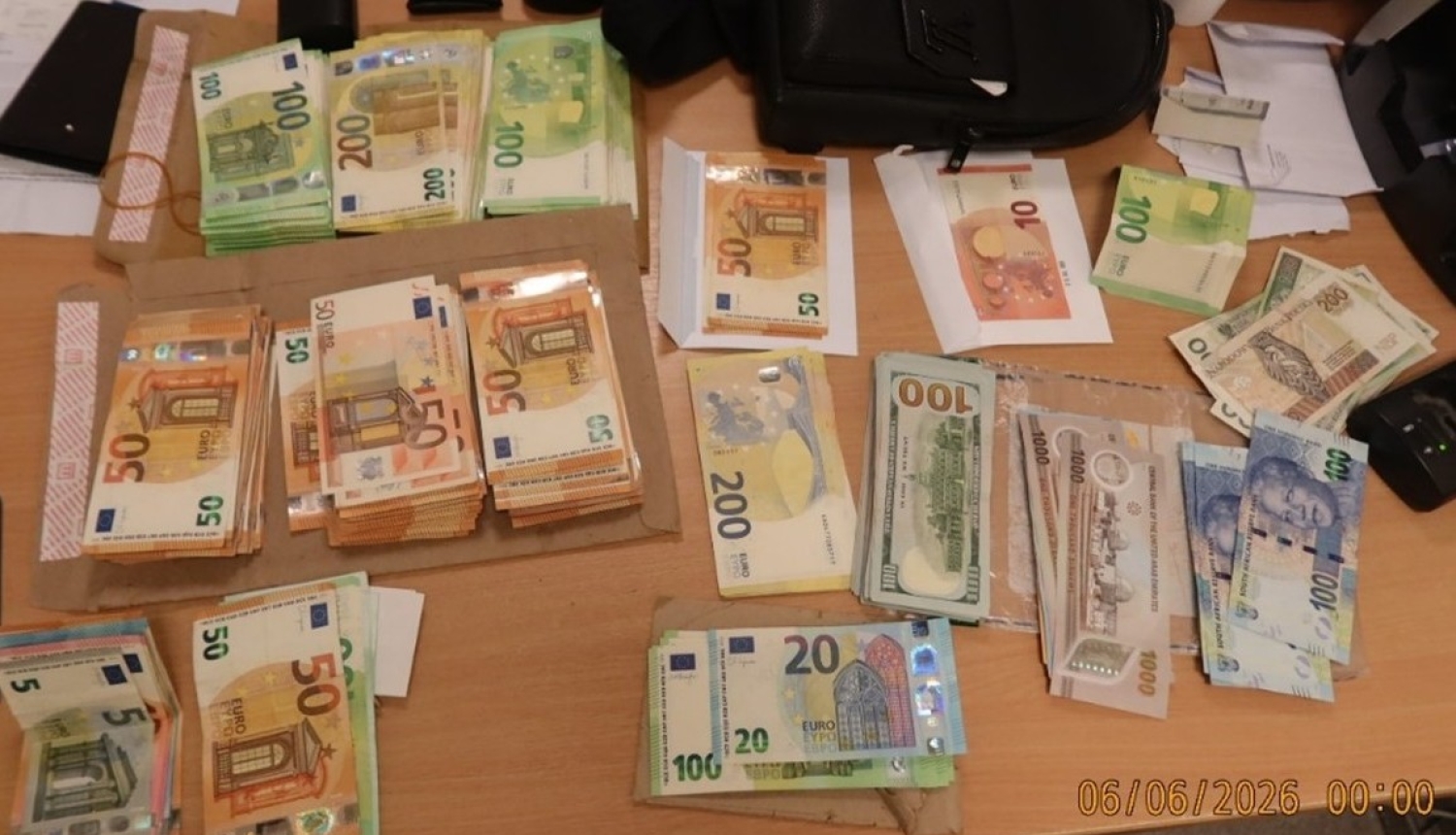Dažādas eiro banknotes sakrautas kaudzītēs, uz galda virsmas 