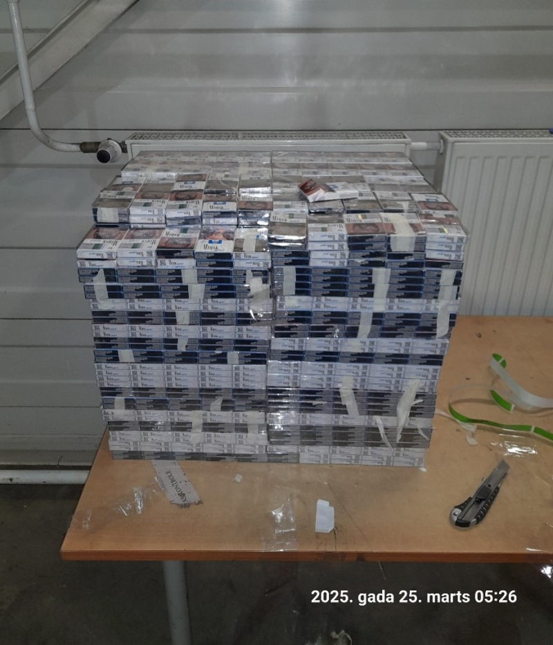 Uz galda salikts plēvē ietīts liels daudzums cigarešu paciņu 