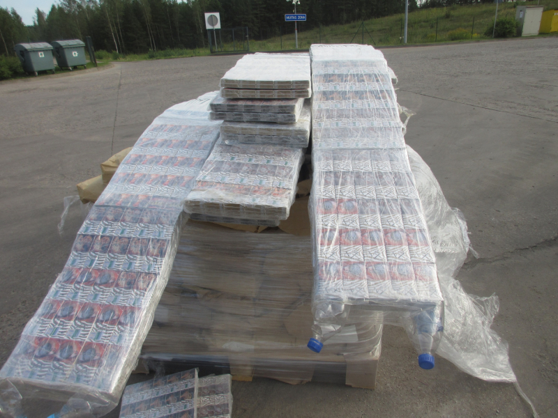 Uz papīra maisiem uzlikti plēvē ietīti daudz cigarešu iepakojumi 