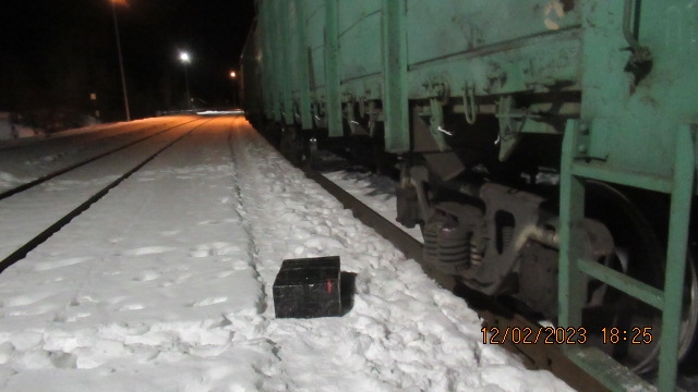 Melna kaste sniegā pie vilciena vagona