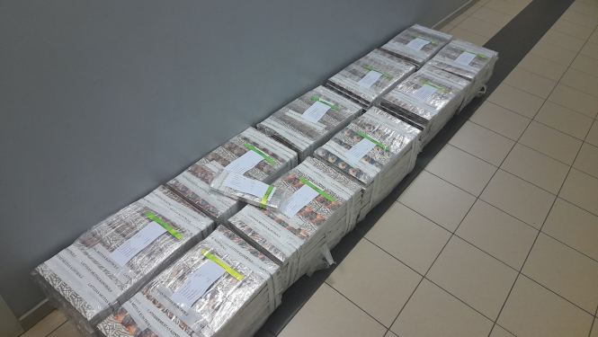 10 plēvē ietītu cigarešu iepakojumi salikti uz grīdas