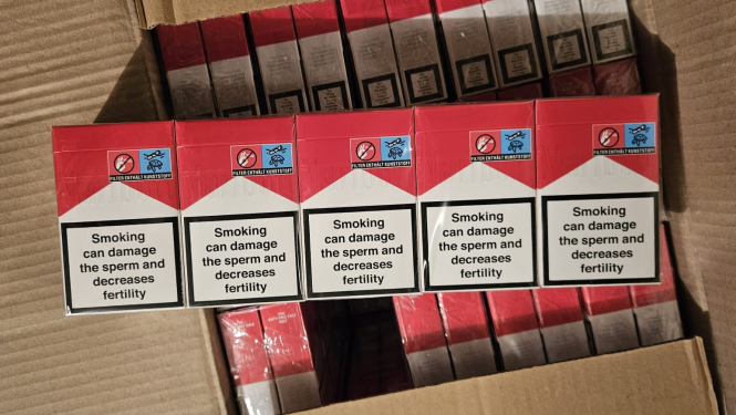 Uz kastes uzliktas piecas cigarešu paciņas sarkanā un baltā krāsā 