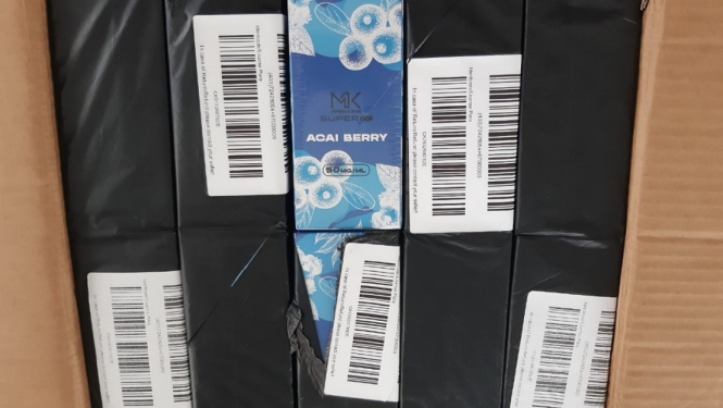 Atvērta kaste ar melnā plēvē iepakotām elektroniskajām cigaretēm 