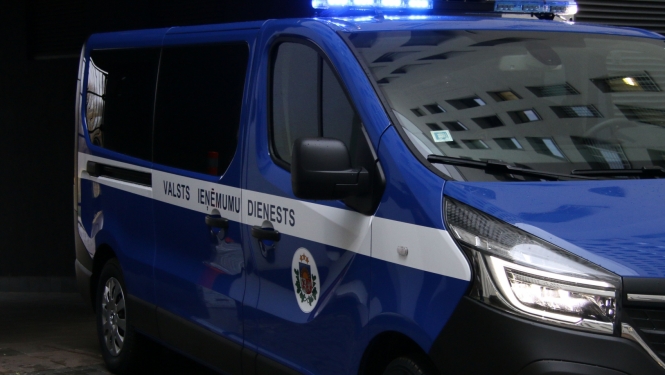 Automašīna ar iedegtām bākugunīm un uzrakstu uz sāniem '"Valsts ieņēmumu dienests"