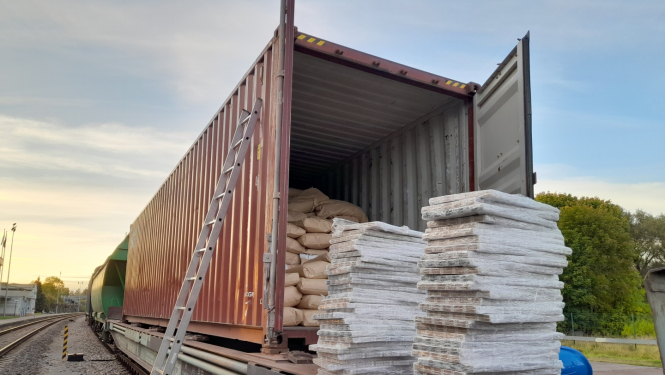 Vilciena vagons pilns ar papīra maisiem, blakus daudz plēvē ietītas cigaretes 