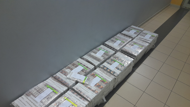 10 plēvē ietītu cigarešu iepakojumi salikti uz grīdas