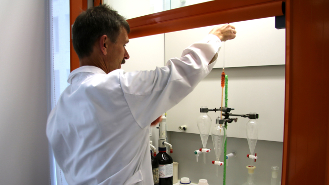 Muitas laboratorijas darbinieks halātā, darba procesā