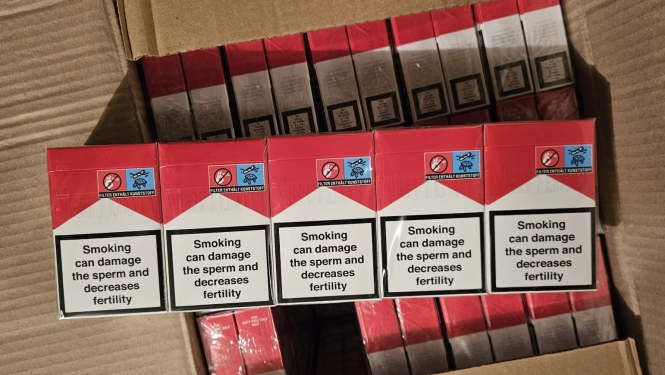 Uz kastes uzliktas piecas cigarešu paciņas sarkanā un baltā krāsā 