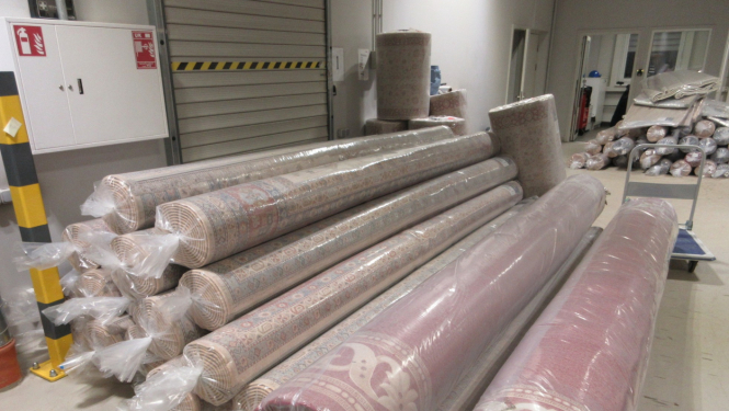 Vairāki grīdas paklāji plastmasas iepakojumos