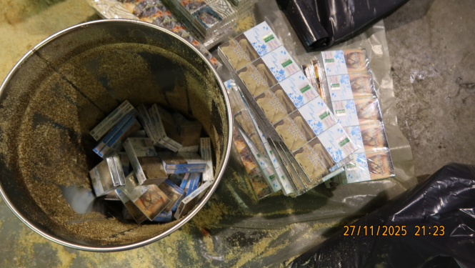 Kontrabandas cigaretes, kas paslēptas aizvākotos metāla spaiņos, zem zāģskaidām