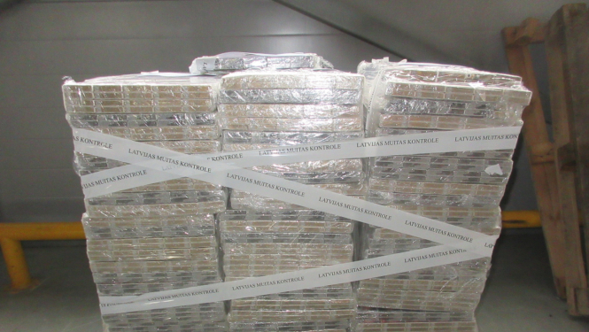 Uz koka paletes uzlikti daudz plēvē ietīti cigarešu iepakojumi 