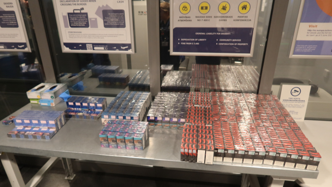 Daudz zilas un sarkanas cigarešu paciņas uz metāla galda