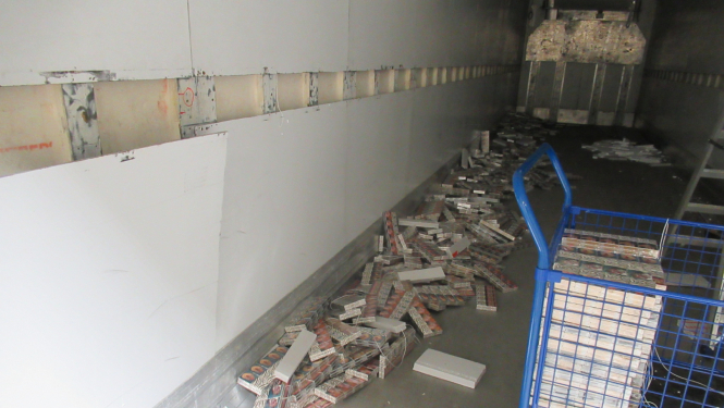 Kravas auto furgonā uz grīdas izbērtas daudz cigarešu paciņas 