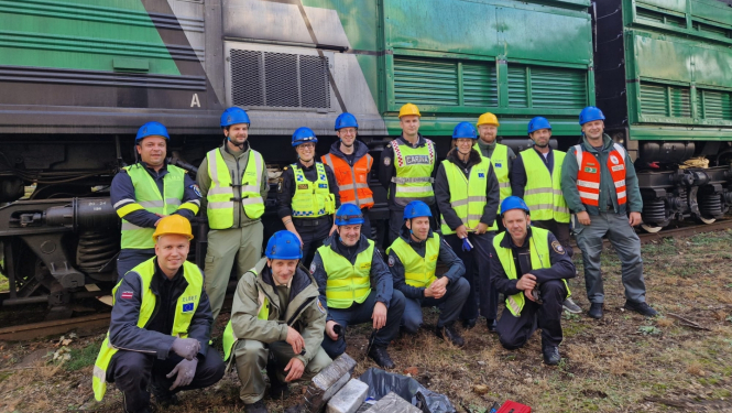 Muitas amatpersonu kopbilde pie kravas vilciena