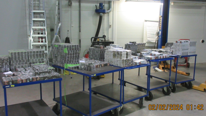 Uz galdiem stāv no automašīnas slēptuvēm izņemtas kontrabandas cigaretes 