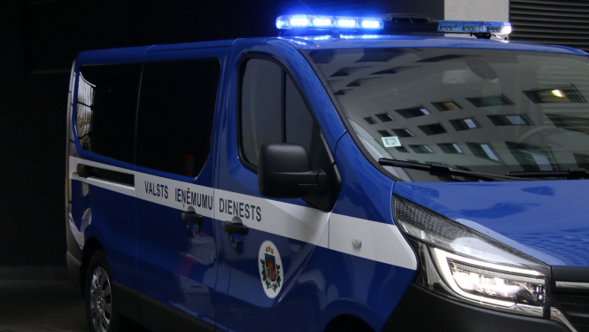 Automašīna ar iedegtām bākugunīm un uzrakstu uz sāniem '"Valsts ieņēmumu dienests"