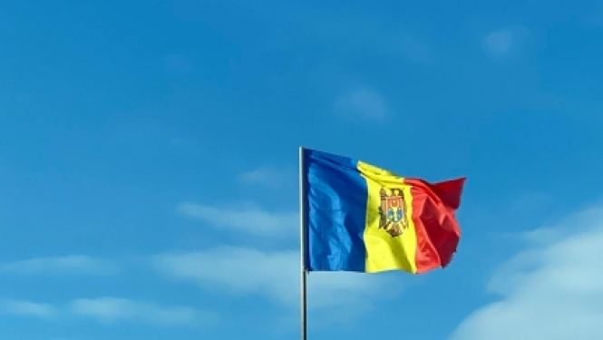 Moldovas karogs uz debesu fona