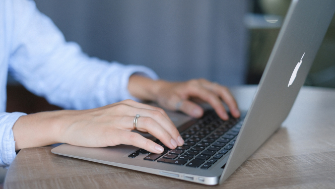 Uz portatīvā datora klaviatūras uzliktas rokas