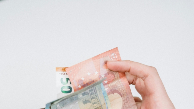 Cilvēka rokās naudas maks ar banknotēm