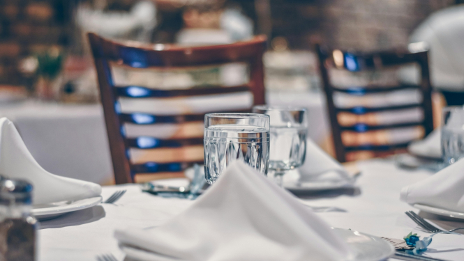 Uzklāts galds priekšplānā salvete un šķīvis