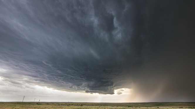 Tumši mākoņi un pļava