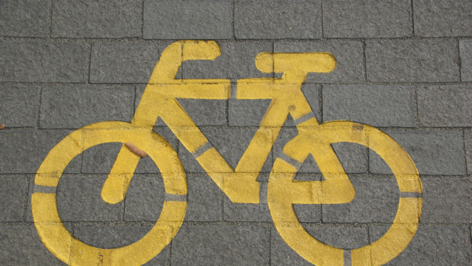 Vizuāls dzeltens velo uzzīmēts uz bruģa