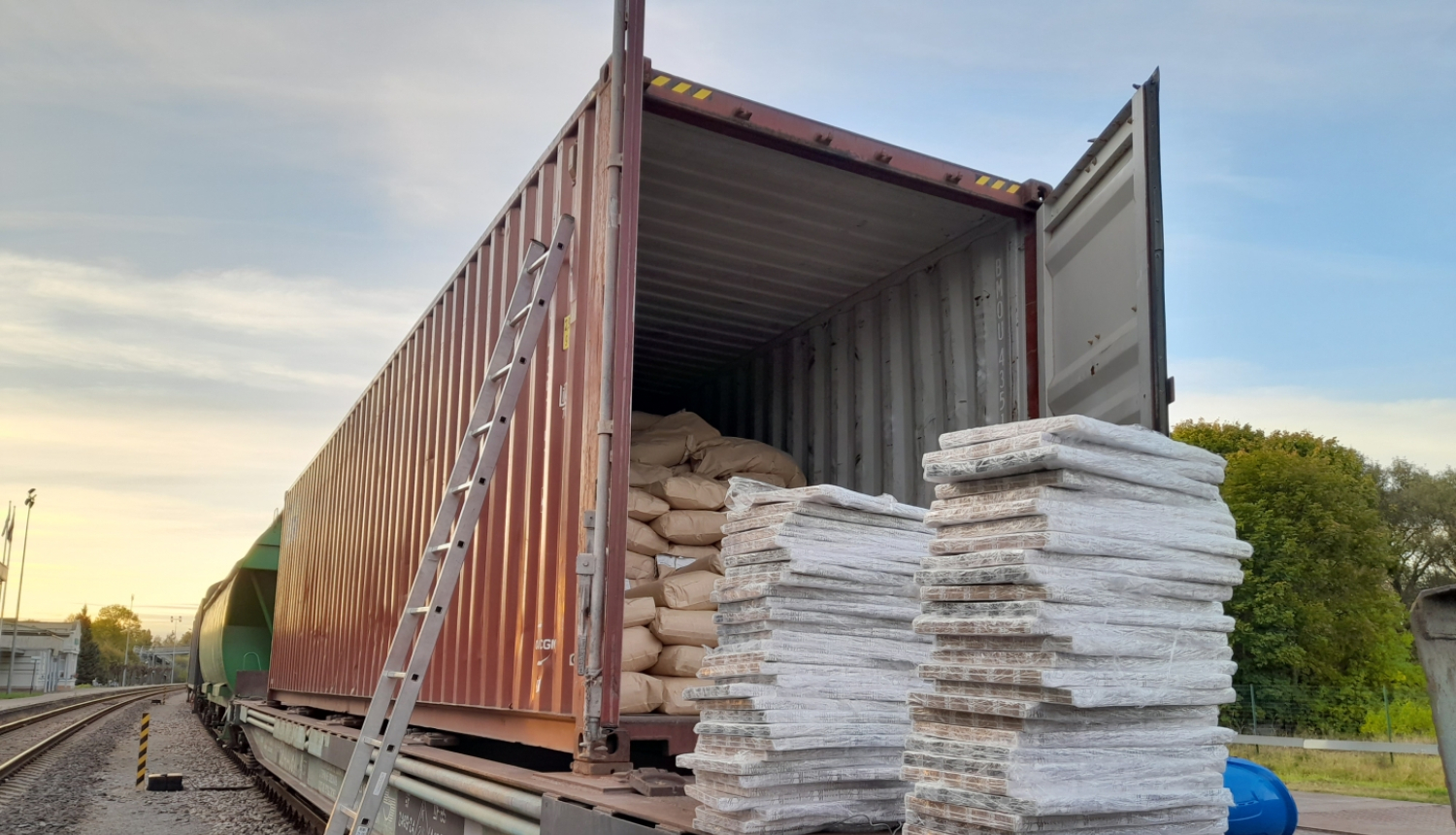 Vilciena vagons pilns ar papīra maisiem, blakus daudz plēvē ietītas cigaretes 