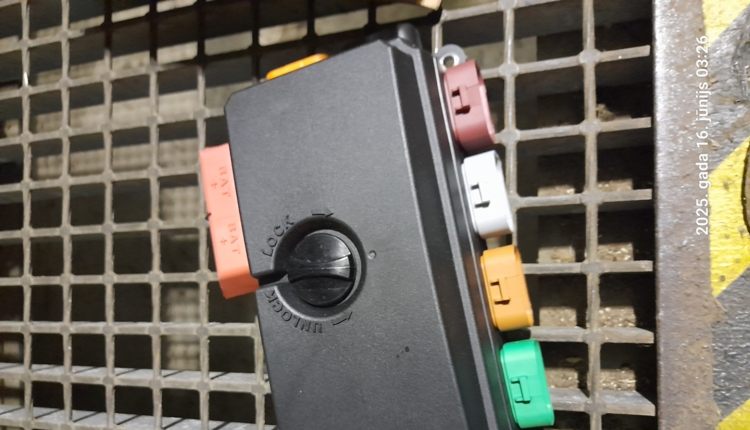 Uz metāla režģa novietota lauksaimniecības tehnikas rezerves daļa 