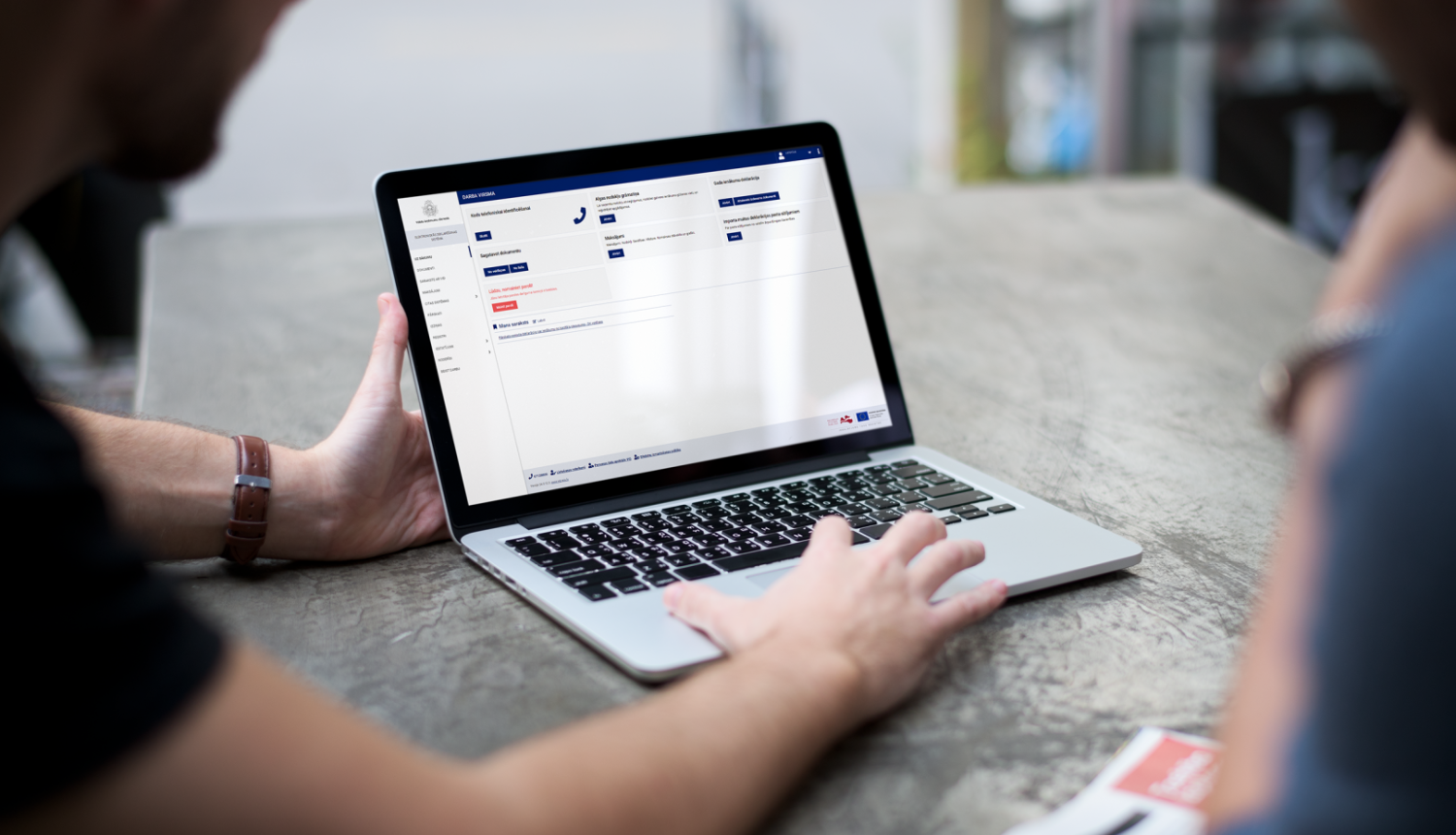 Atvērts portatīvais dators ar rokām uz klaviatūras 