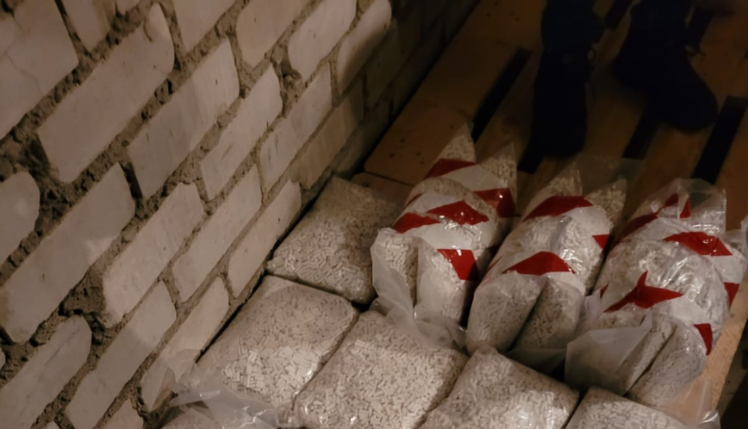 Uz grīdas caurspīdīgi iepakojumi ar baltām narkotiskajām vielām 