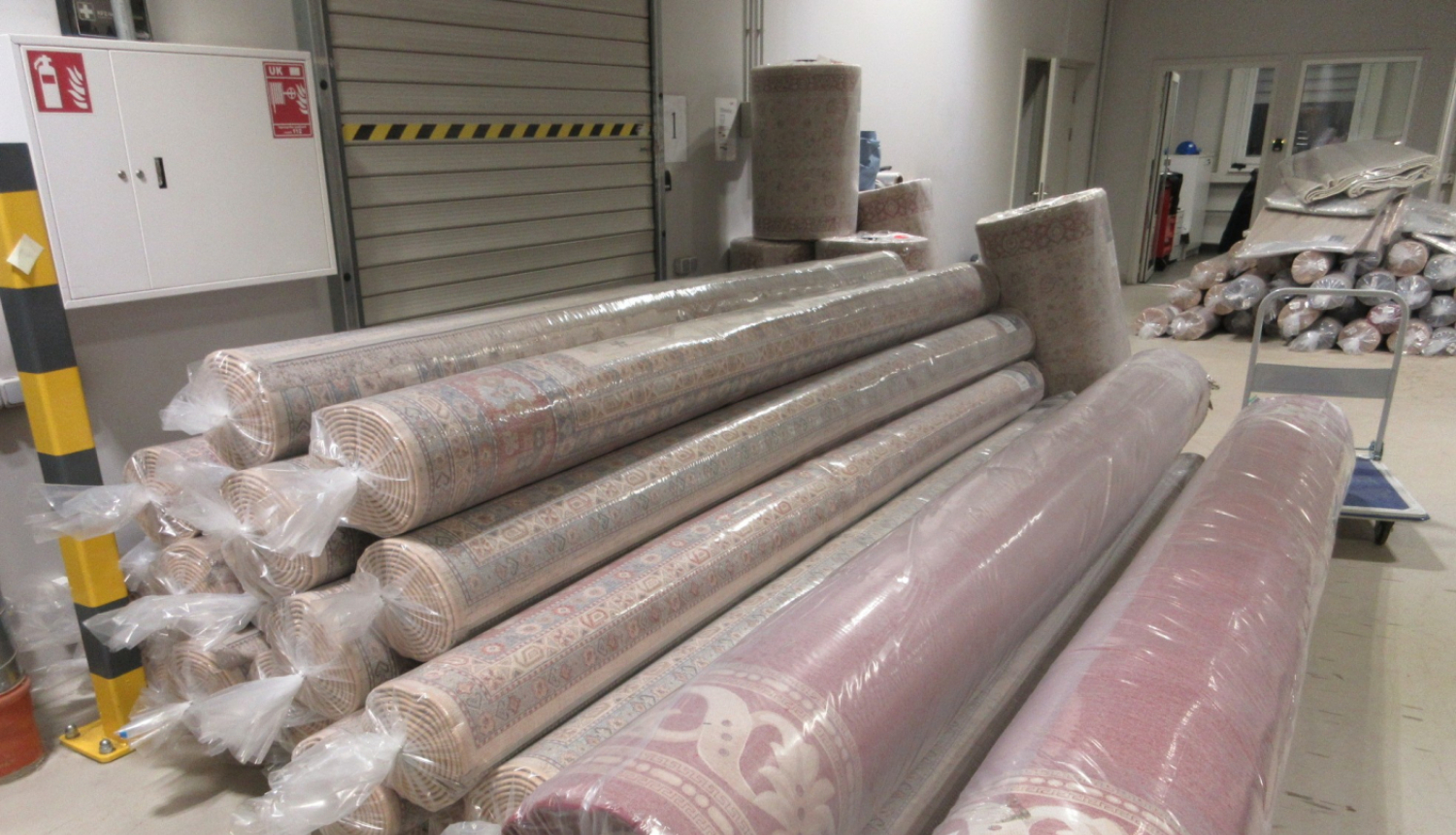 Vairāki grīdas paklāji plastmasas iepakojumos