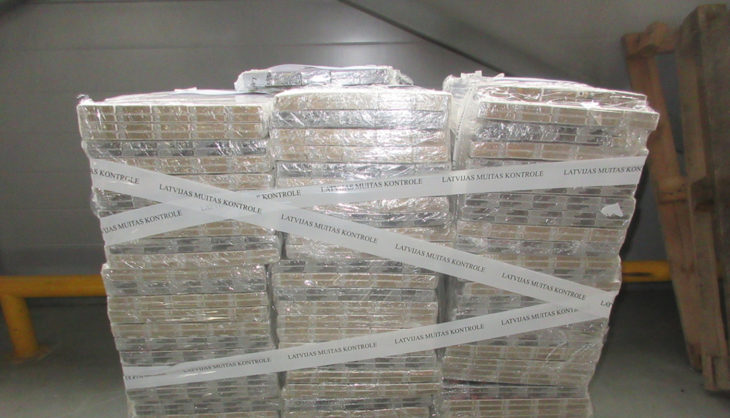 Uz koka paletes uzlikti daudz plēvē ietīti cigarešu iepakojumi 