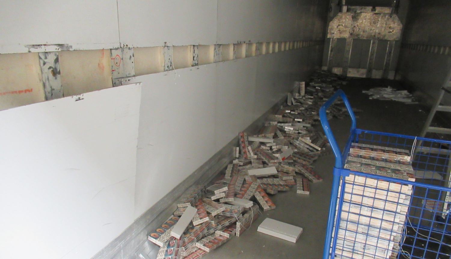 Kravas auto furgonā uz grīdas izbērtas daudz cigarešu paciņas 