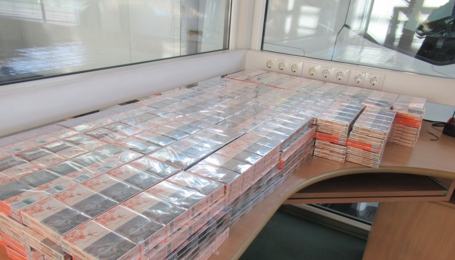 uz galda salikts liels daudzums cigarešu iepakojumu 