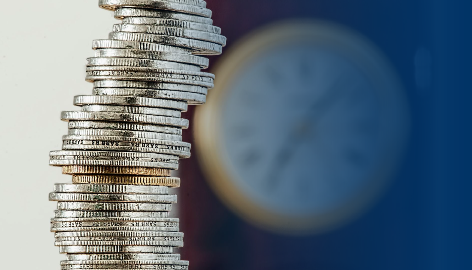 Monētas kaudzītē, fonā pulkstenis