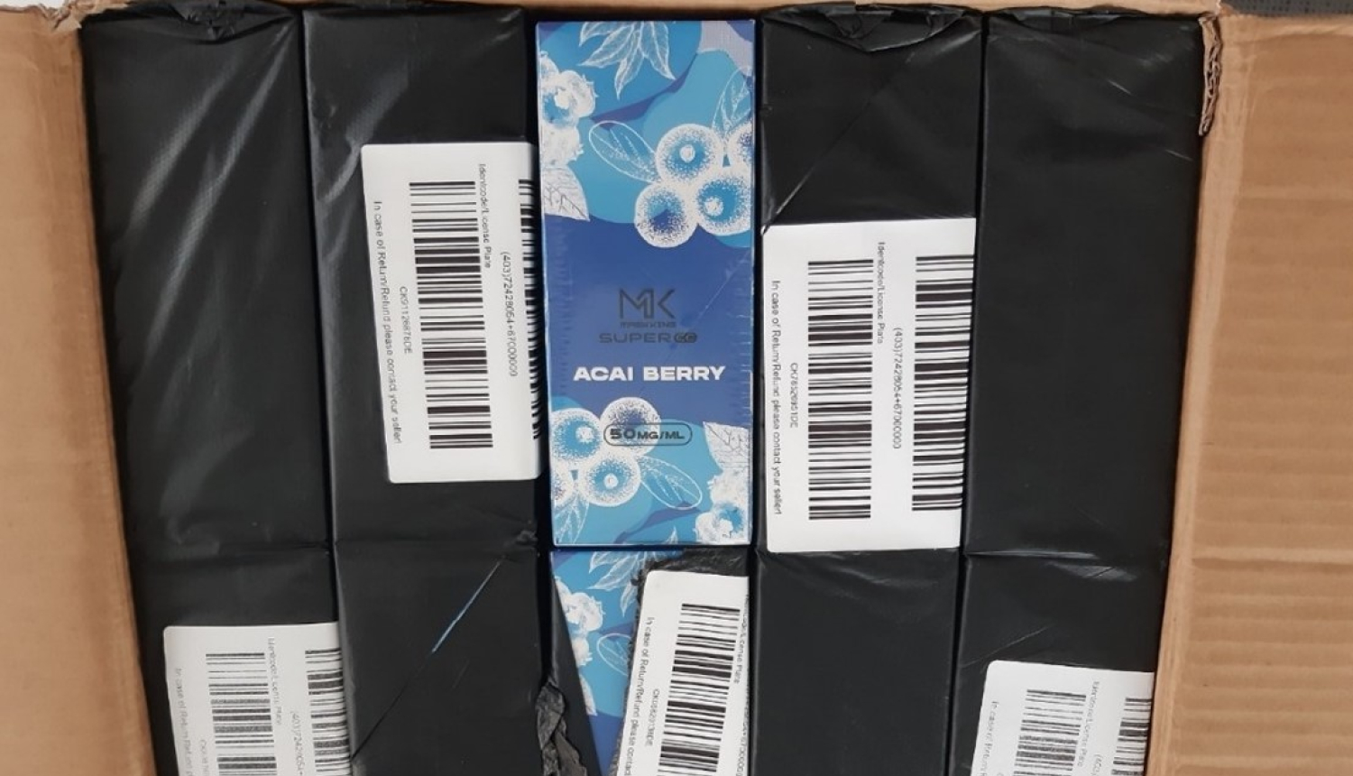 Atvērta kaste ar melnā plēvē iepakotām elektroniskajām cigaretēm 