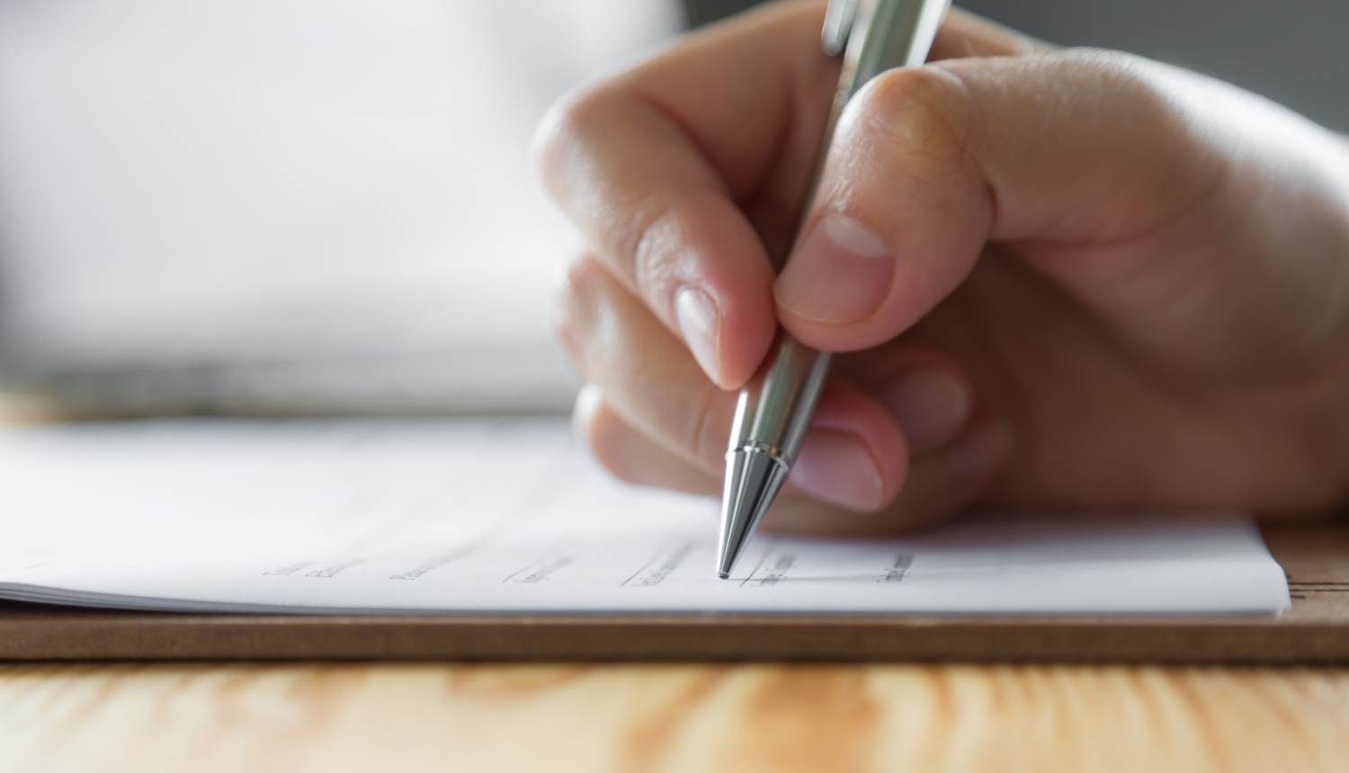Roka tur pildspalvu un raksta uz papīra