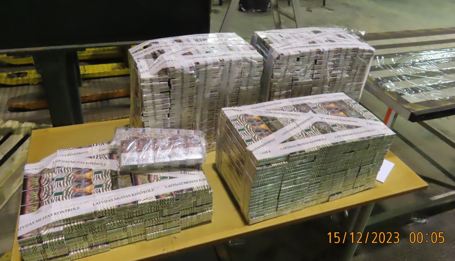 Lieli iepakojumi ar muitas amatpersonu izņemtām kontrabandas cigaretēm “NZ Gold” stāv uz galda