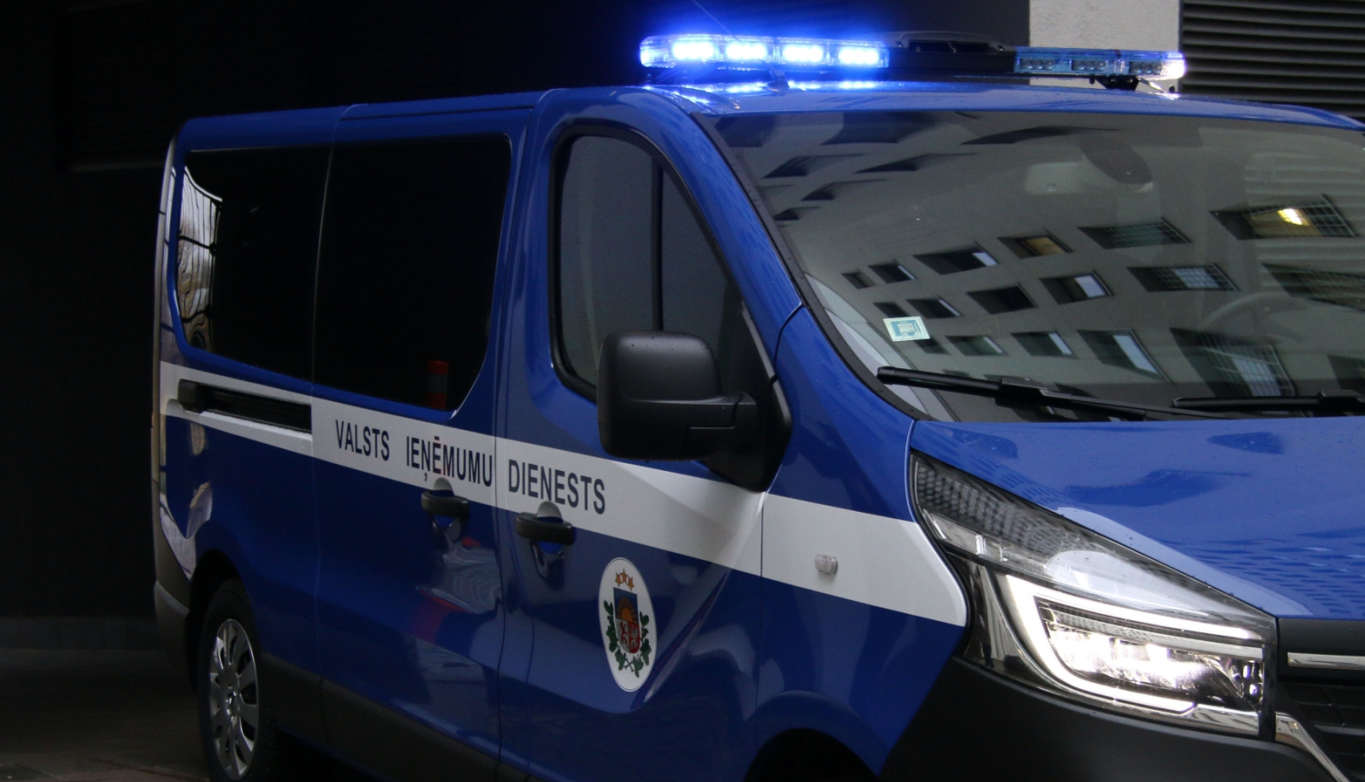 Automašīna ar iedegtām bākugunīm un uzrakstu uz sāniem '"Valsts ieņēmumu dienests"