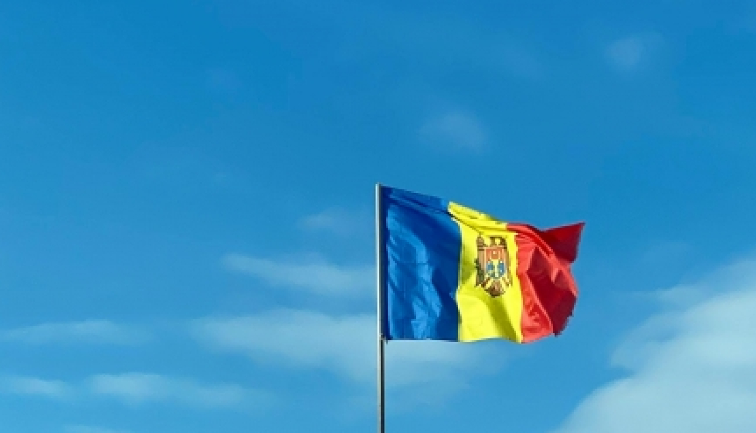 Moldovas karogs uz debesu fona