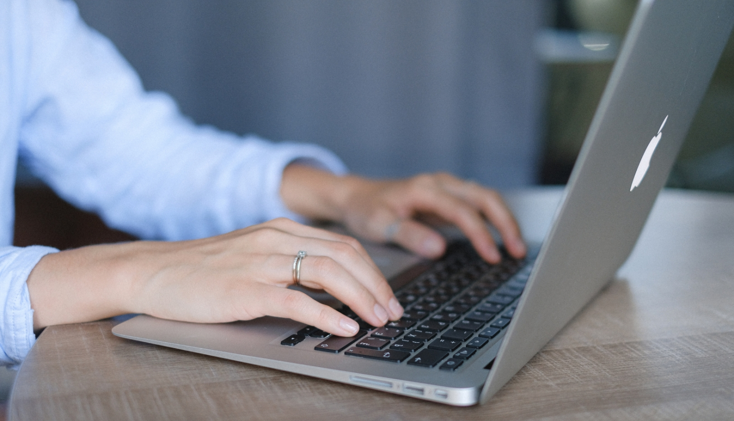 Uz portatīvā datora klaviatūras uzliktas rokas