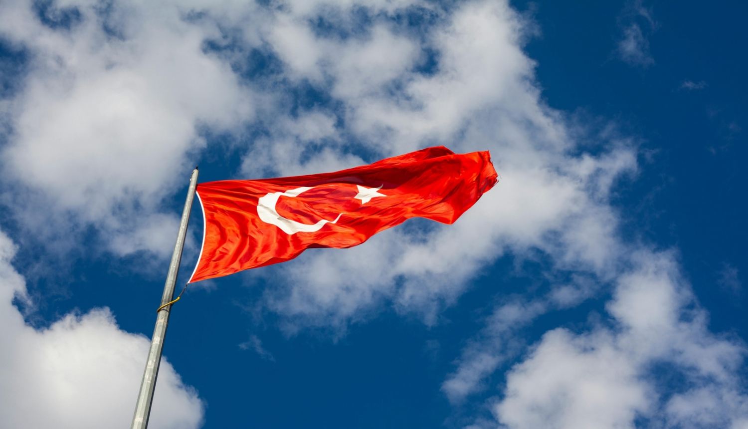Uz zila debesu fona Turcijas karogs mastā 
