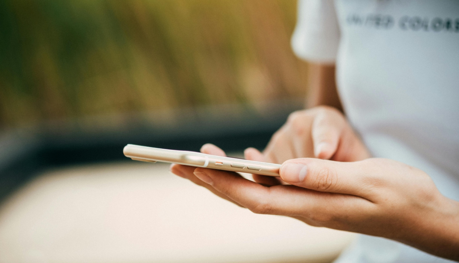 Sieviete tur rokās mobilo telefonu