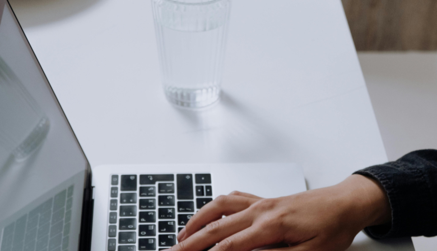 Rokas uz laptopa klaviatūras