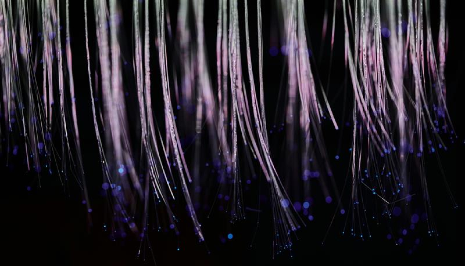 Izgaismotas stikla šķiedras uz melna fona