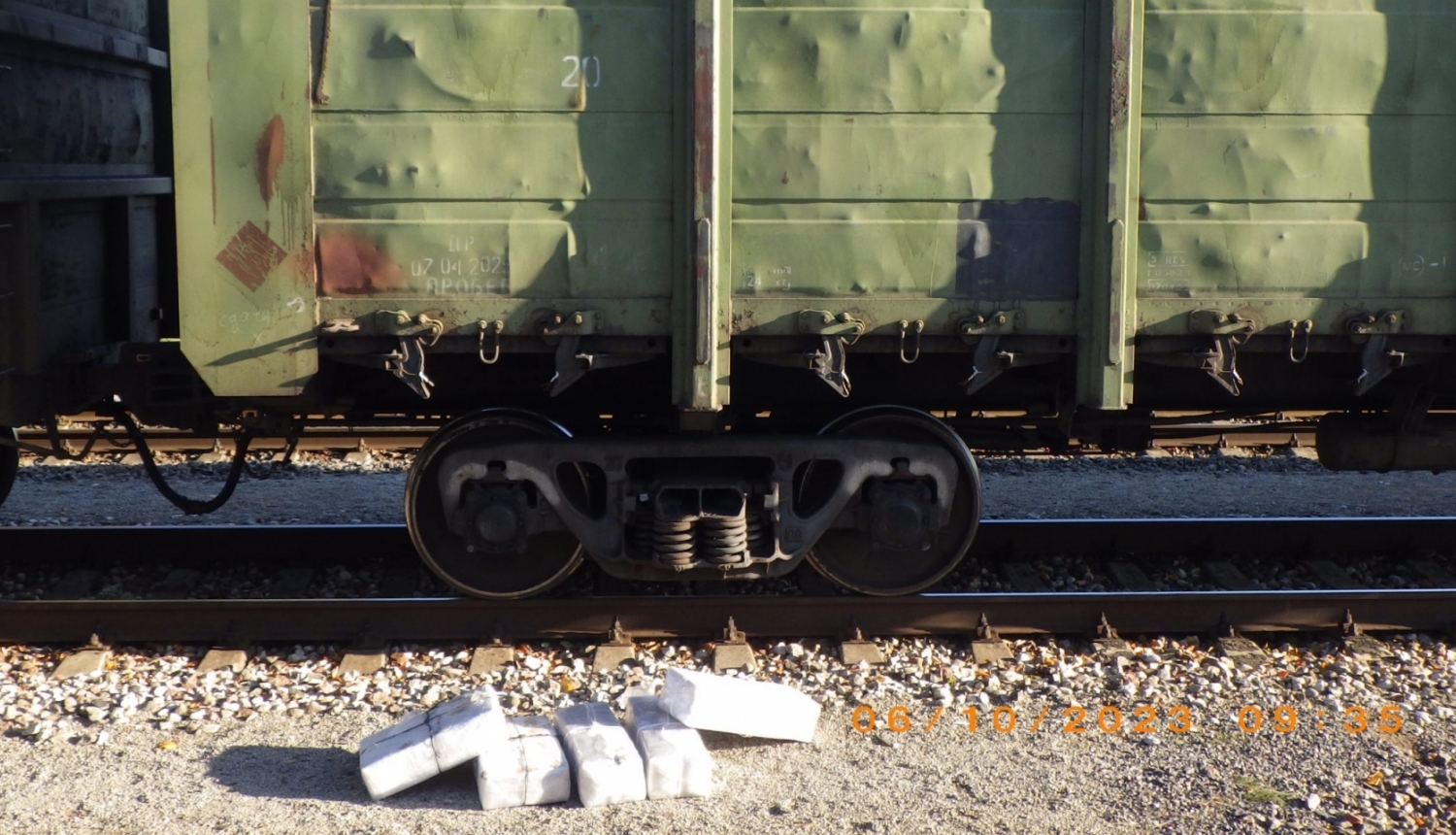 Blakus vilciena vagonam stāv baltā plēvē ietītas pakas, kurās atrodas kontrabandas cigaretes